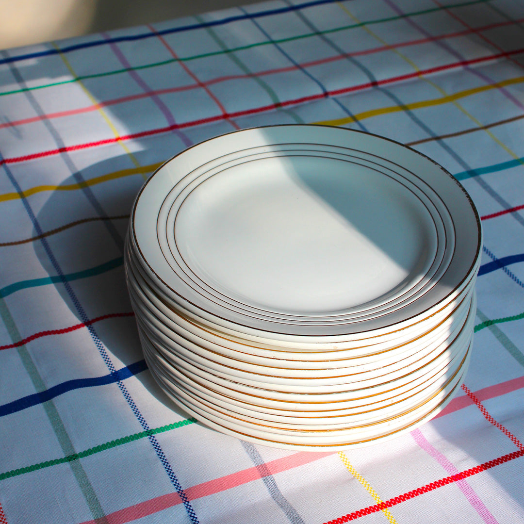 12 assiettes plates en faïence aux liserés dorés