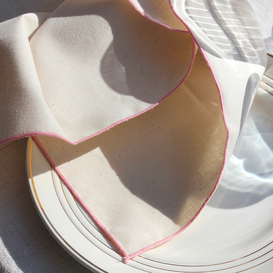 Quatre serviettes en coton écru avec bourdons pastels