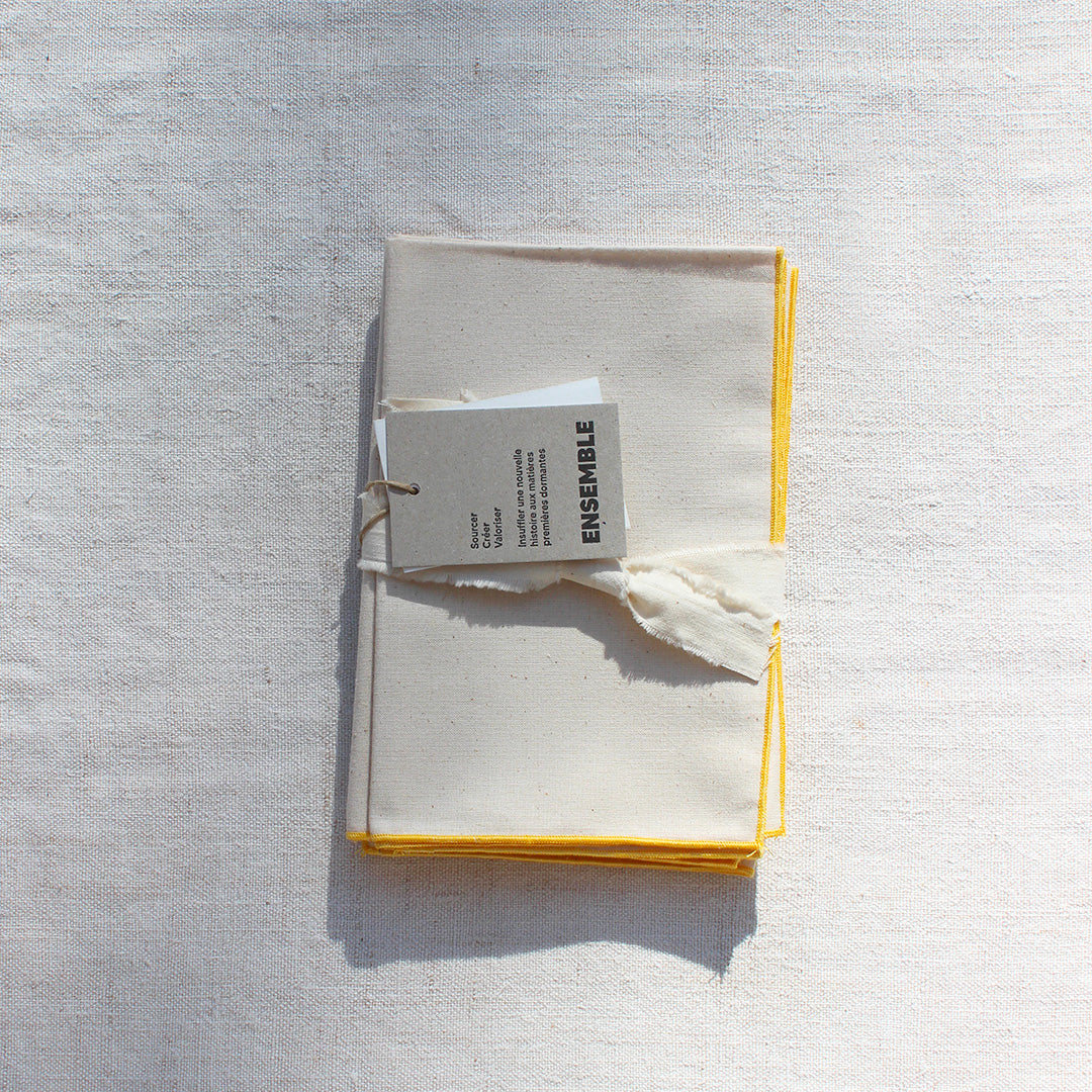 Quatre serviettes en coton écru avec bourdons pastels