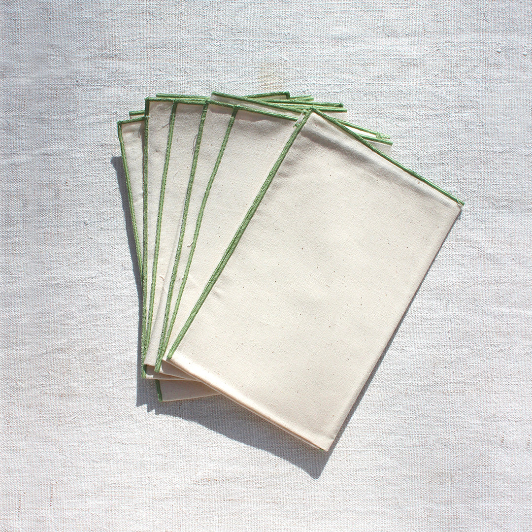 Quatre serviettes en coton écru avec bourdons pastels