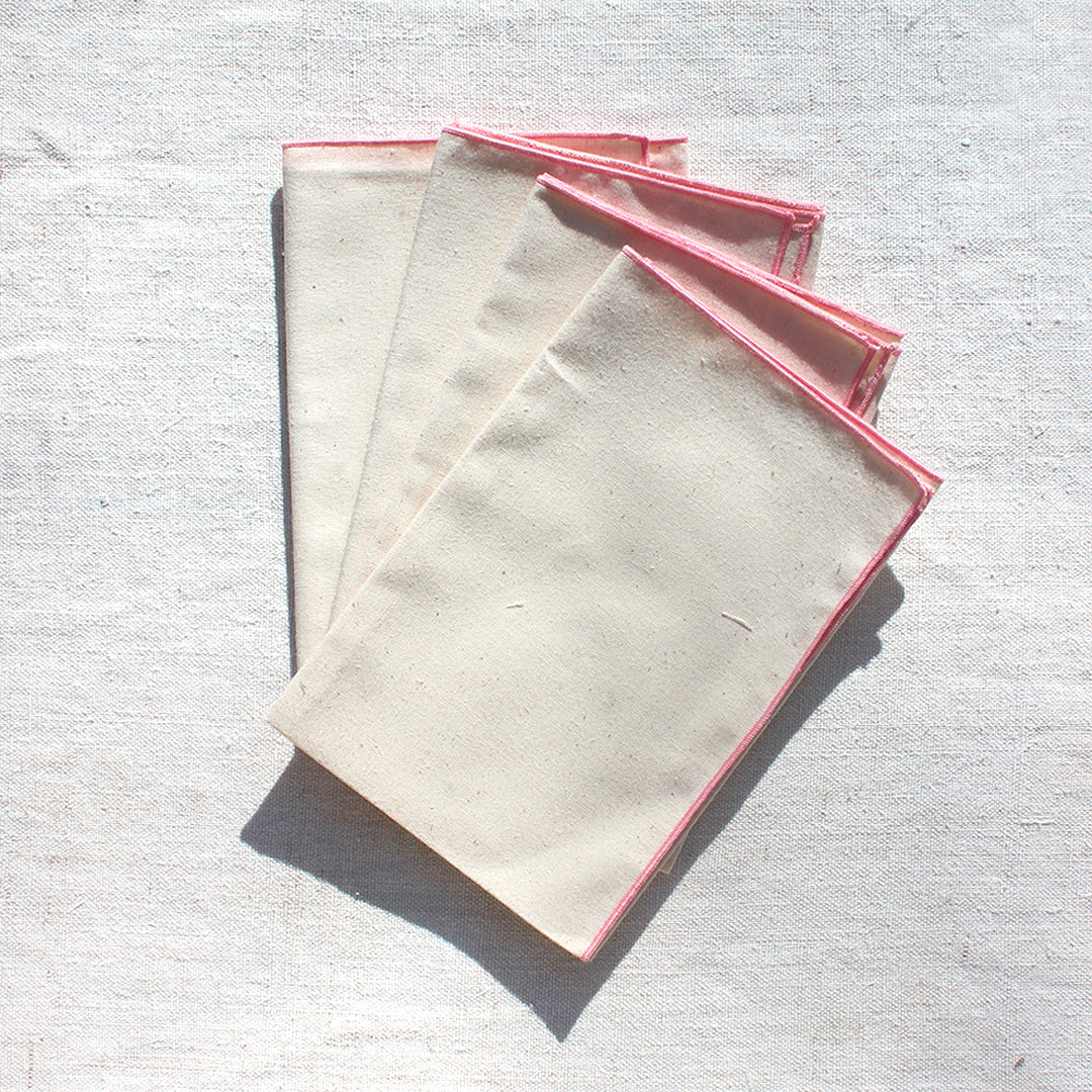 Quatre serviettes en coton écru avec bourdons pastels