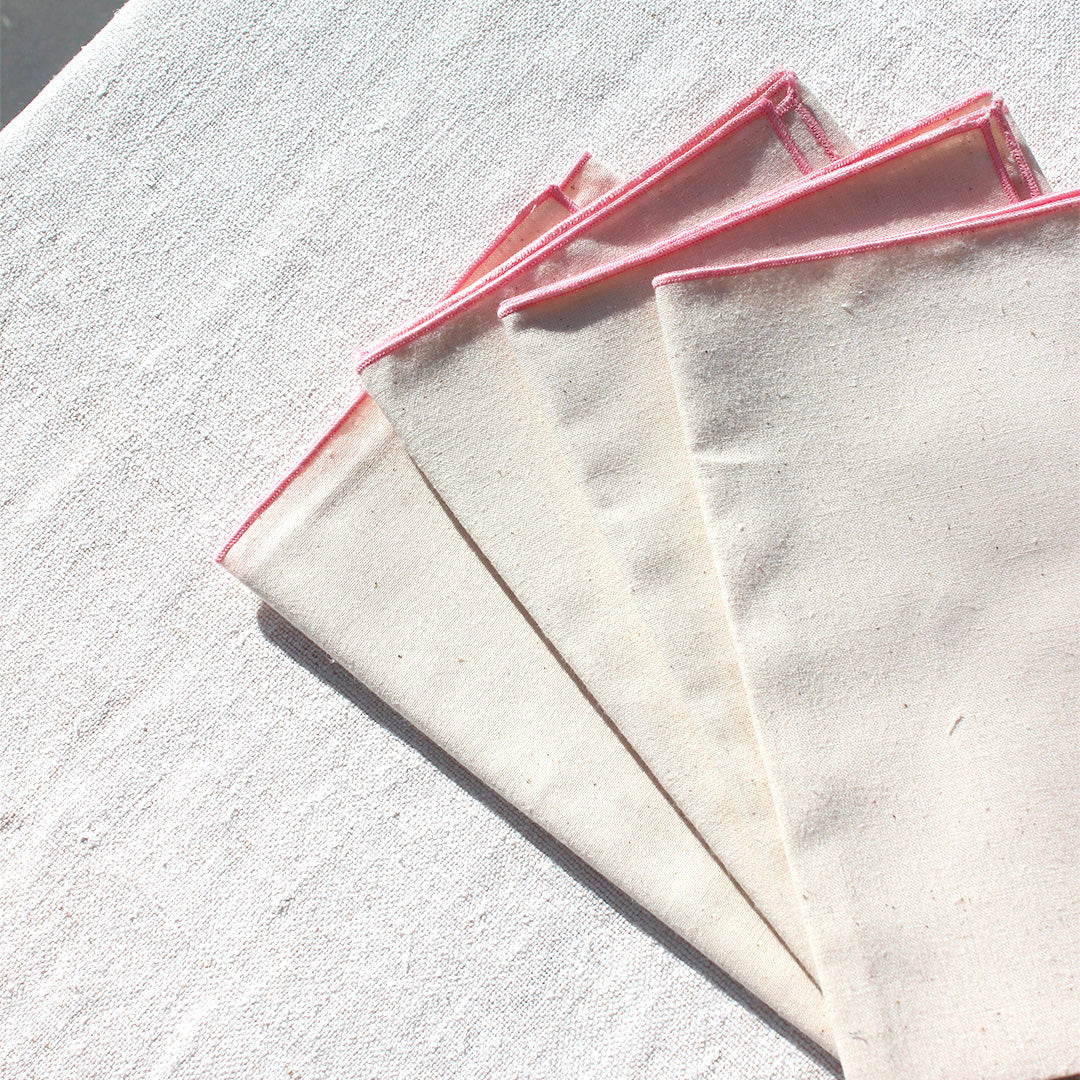 Quatre serviettes en coton écru avec bourdons pastels