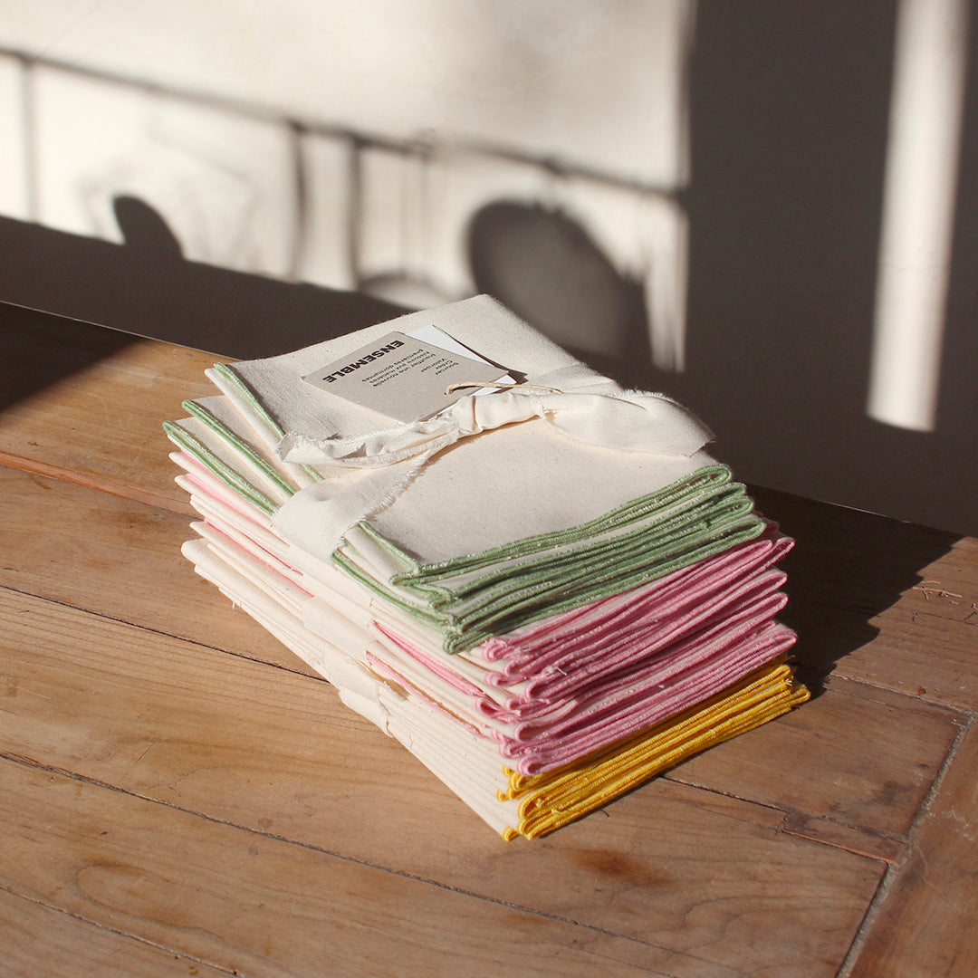 Quatre serviettes en coton écru avec bourdons pastels