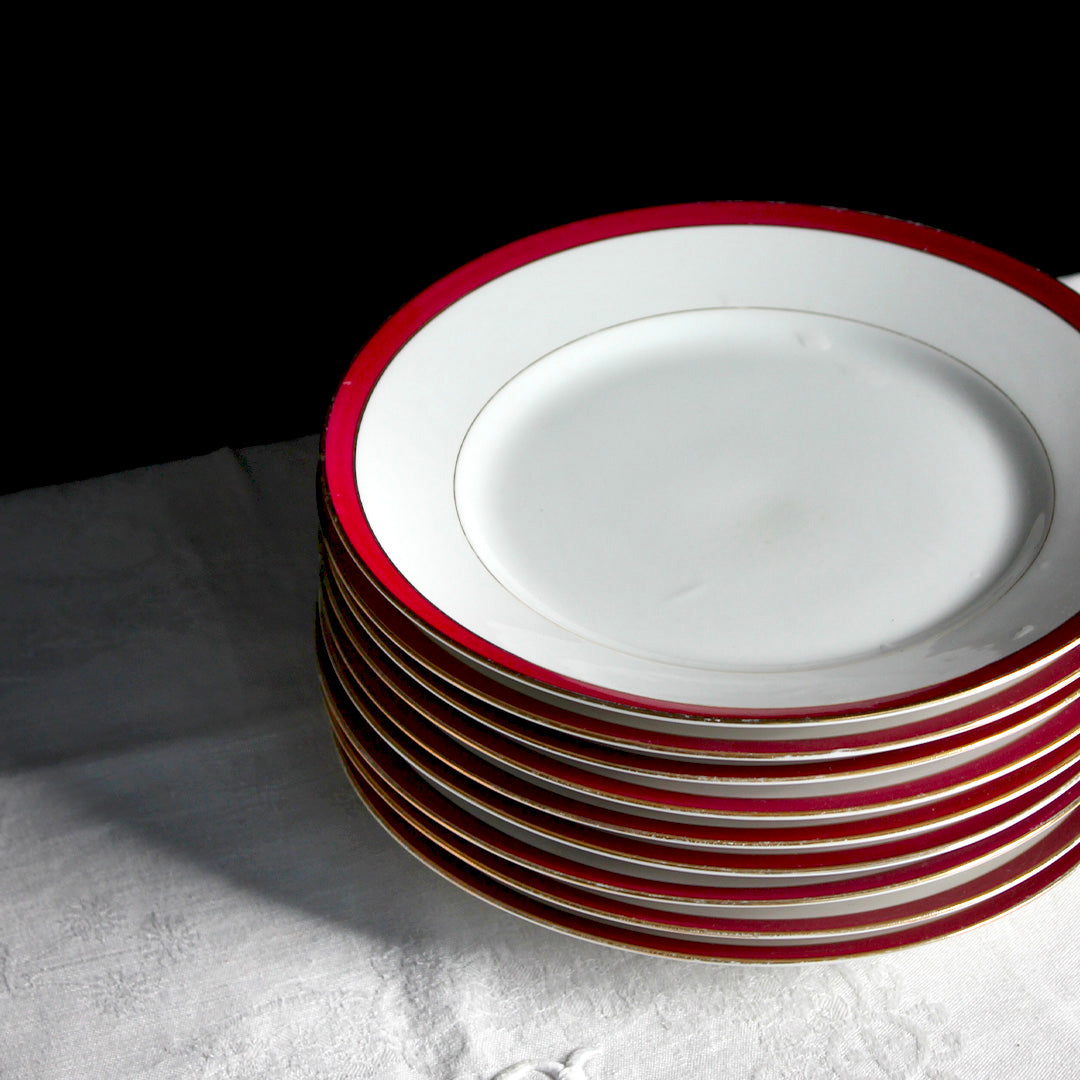 9 assiettes en porcelaine liseré framboise